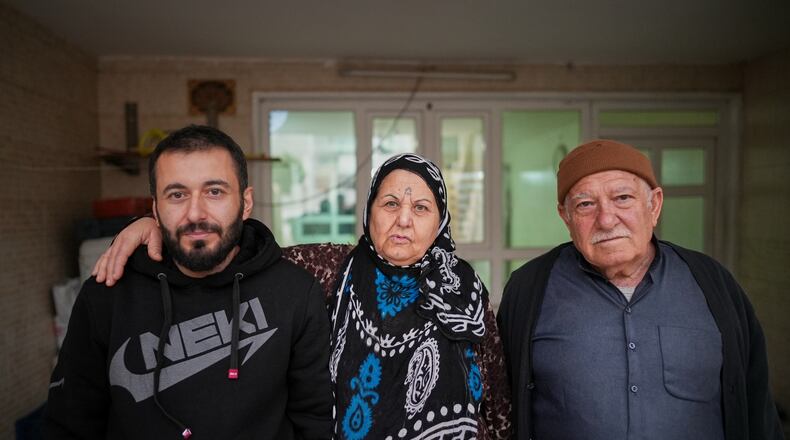 Syrian refugee Mohammed Dawood, 30, left, poses for a photo with his parents, Hayat Fatah, 65, center, and Abdulilah Amin Dawoud, 73, at their home in Irbil, Iraq, Nov. 16, 2025. (AP Photo/Farid Abdulwahed)