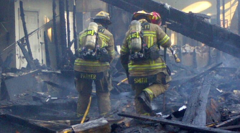 Gwinnett County fire crews battled the blaze, which spread to the adjacent woods, using aerial ladders and multiple hose lines. (Credit: Gwinnett County Department of Fire and Emergency Services)