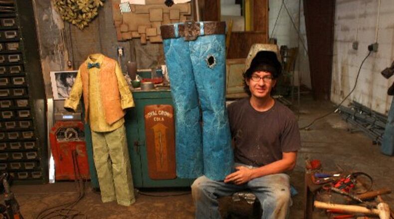 Dalton artist Chris Beck, holding up one of his sculptures in his studio, will show his works at Folk Fest this weekend.