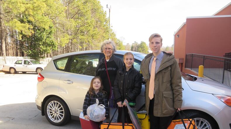 Delivering Meals on Wheels to Cobb County seniors has been a rewarding family tradition for the Ingolds and their children and grandchildren. Pictured with Carolyn Ingold are her grandchildren, from left, Carter Brandon, 6, Kennedy Wilson, 13, and Lincoln Wilson, 17. The family is packed up and ready to head out on their delivery route. Photo by Laura Berrios.