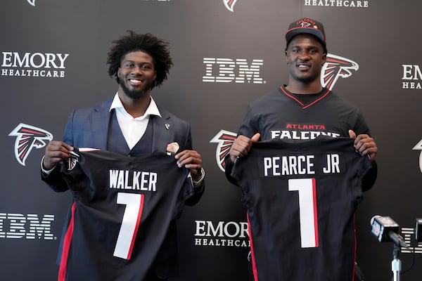 Atlanta Falcons first-round draft picks Jalon Walker, left and James Pearce Jr., right, hold up their jerseys during a news conference, Friday, April 25, 2025, in Flowery Branch, Ga. (AP Photo/Brynn Anderson)