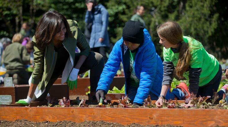 First lady Michelle Obama, left, with students from across the country, plant vegetables during the eight annual White House Kitchen Garden planting on the South Lawn of the White House in Washington, Tuesday, April 5, 2016. Obama will visit Burke County Middle School near Augusta on Thursday to help students there plant the school garden. (AP Photo/Pablo Martinez Monsivais)