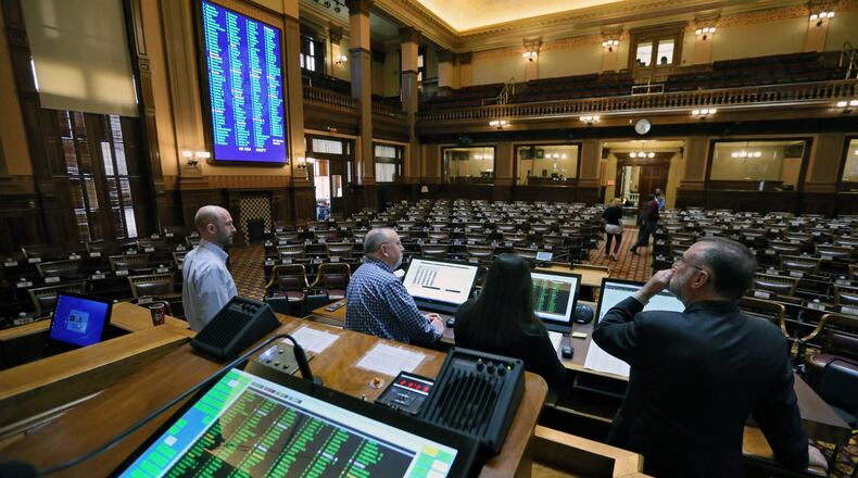 The clerk of the House, Bill Reilly, right, and other members of the House Clerk’s Office staff test new voting equipment in preparation for the start of the Georgia General Assembly on Monday. BOB ANDRES /BANDRES@AJC.COM