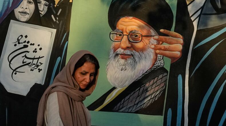 A woman walks past a mural depicting a portrait of the late Iranian Supreme Leader Ayatollah Ali Khamenei, who was killed in the U.S. and Israel strike on Feb. 28, in downtown Tehran, Iran, Saturday, July 18, 2026. (AP Photo/Vahid Salemi)
