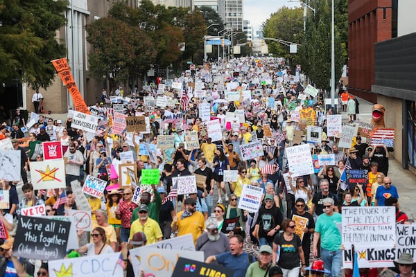 Demonstrators lined the streets with signs during a “No Kings” march in Atlanta in October 2025. (Abbey Cutrer/AJC)