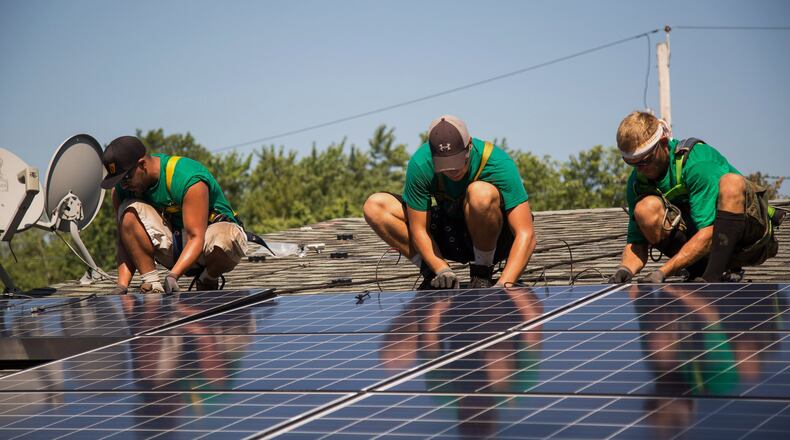 Solar panels, which are appearing in more places around the U.S., are likely to become a much more common sight on Atlanta homes in the next few years. (Here, they’re being installed on the roof of a home in Kendall Park, N.J.) MICHAEL NAGLE / BLOOMBERG 2015