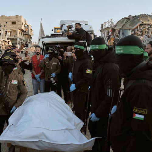 Masked Islamic Jihad and Hamas militants hand over a body bag believed to contain the remains of a deceased hostage to the Red Cross for transfer to Israeli authorities, in Beit Lahiya, in the northern Gaza Strip, Wednesday, Dec. 3, 2025. (AP Photo/Jehad Alshrafi)