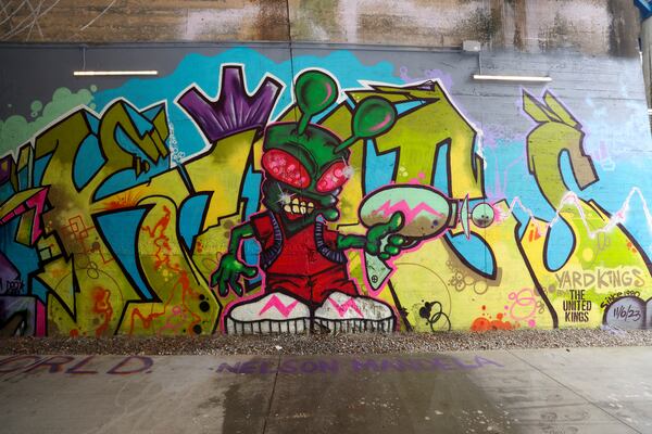 Recent work of the graffiti crew, the United Kings, is shown on the Beltline’s West Trail under the Lee Street tunnel. (Jason Getz / jason.getz@ajc.com)
