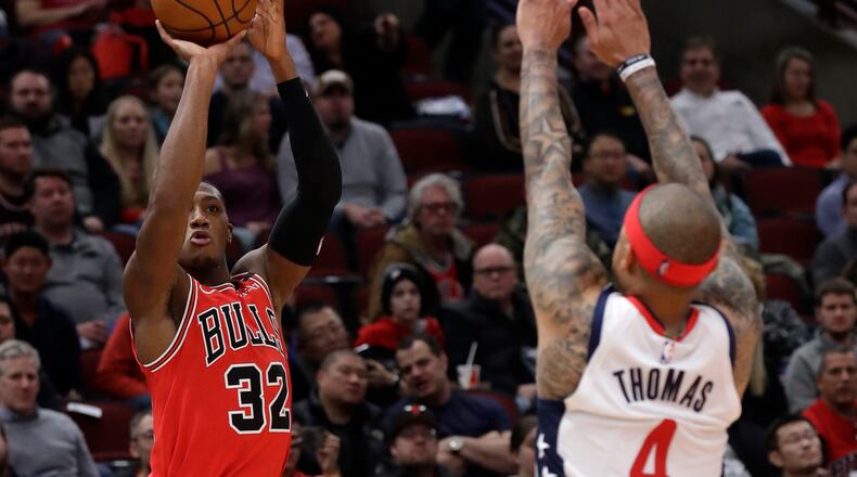 Chicago Bulls guard Kris Dunn, left, shoots against Washington Wizards guard Isaiah Thomas during the second half of an NBA basketball game in Chicago, Wednesday, Jan. 15, 2020. The Bulls won 115-106. (AP Photo/Nam Y. Huh)