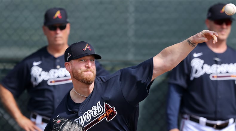Braves reliever Will Smith stretches out his arm and his new uniform this spring, while manager Brian Snitker (left) and bullpen coach Marty Reed look on. (Curtis Compton ccompton@ajc.com)