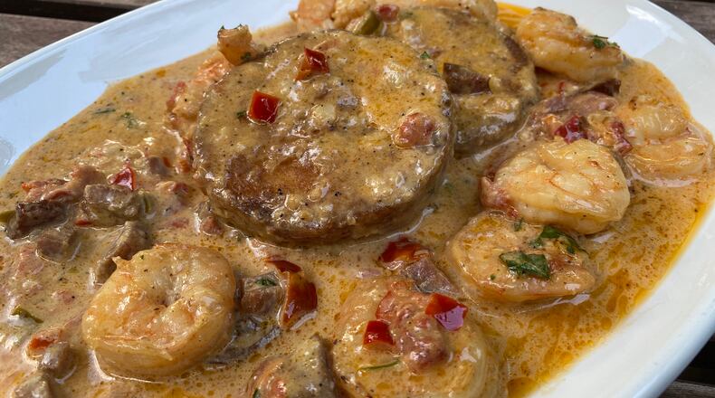 Bayou’Q features sauteed shrimp in Cajun gravy, dotted with smoked tasso ham and andouille sausage, over cheesy grits cakes. Ligaya Figueras/ligaya.figueras@ajc.com.
