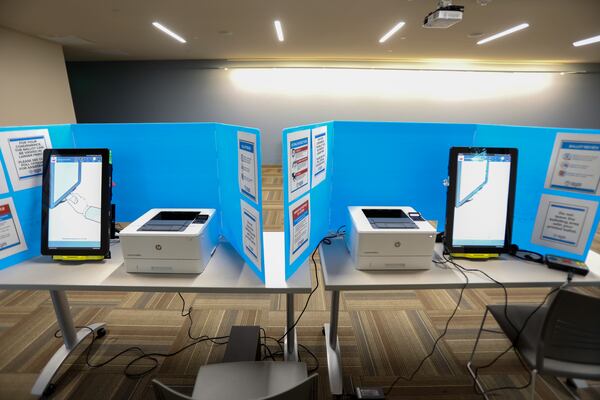 Two of the new Fulton County voting machines sit at the Sandy Springs Library on Tuesday Feb. 18, 2020. The new machines print the voter's selections on a paper ballot which is then scanned and the vote is cast.