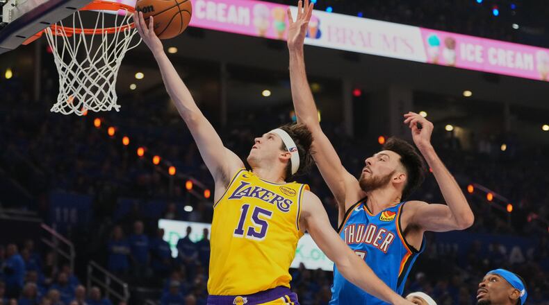 FILE - Los Angeles Lakers guard Austin Reaves (15) shoots after getting past Oklahoma City Thunder center Chet Holmgren, center, and Shai Gilgeous-Alexander, right, in the first half of Game 1 in a second-round NBA basketball playoffs series May 5, 2026 in Oklahoma City. (AP Photo/Kyle Phillips, File)