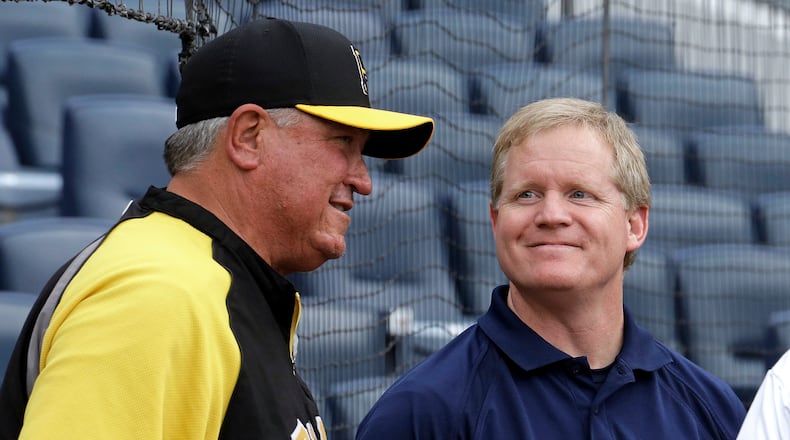 FILE - In this Oct. 5, 2013, file photo, Pittsburgh Pirates manager Clint Hurdle, left, visits with Pirates general manager Neil Huntington during the baseball team's workout in Pittsburgh. The Pittsburgh Pirates have the second-best record in the majors since 2013, a run that restored faith in the franchise after two decades of misery and led to three straight playoff berths. (AP Photo/Gene J. Puskar, File)