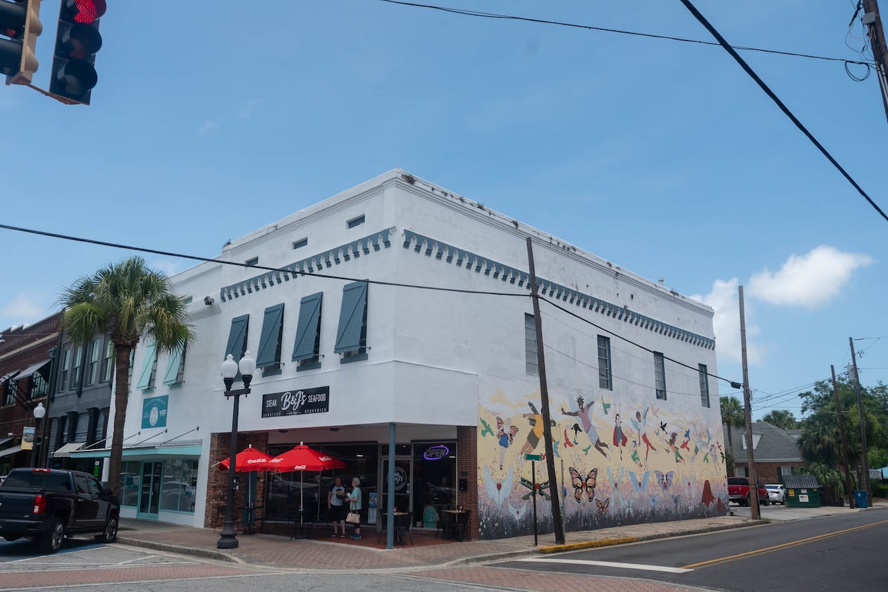 A three-quarter view of a historic building in downtown Brunswick with a mural on one side