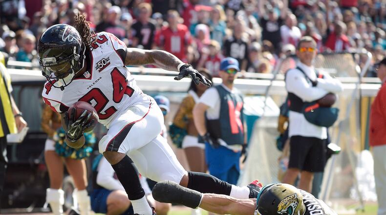 Atlanta Falcons running back Devonta Freeman (24) scores a touchdown on a 5-yard run past Jacksonville Jaguars middle linebacker Paul Posluszny, right, during the first half of an NFL football game in Jacksonville, Fla., Sunday, Dec. 20, 2015. (AP Photo/Phelan M. Ebenhack)