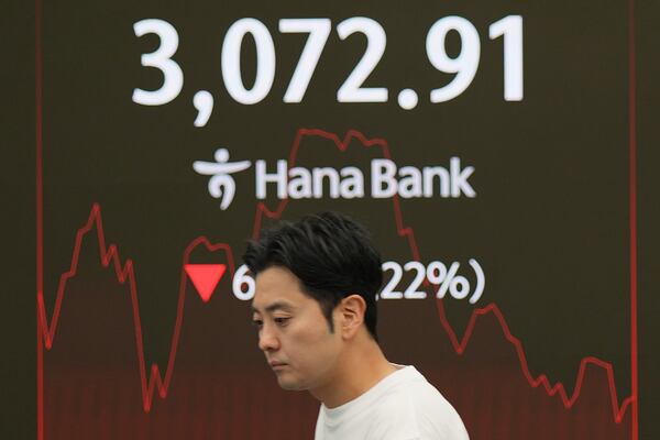 A dealer walks past near screens showing the Korea Composite Stock Price Index (KOSPI) at a dealing room of Hana Bank in Seoul, South Korea, Friday, June 27, 2025. (AP Photo/Lee Jin-man)