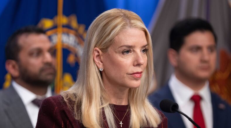 Attorney General Pam Bondi speaks with reporters as FBI Director Kash Patel, left, and Bill Essayli, acting U.S. Attorney for the Central District of California listen during a news conference at the Department of Justice, Wednesday, Nov. 19, 2025, in Washington. (AP Photo/Mark Schiefelbein)