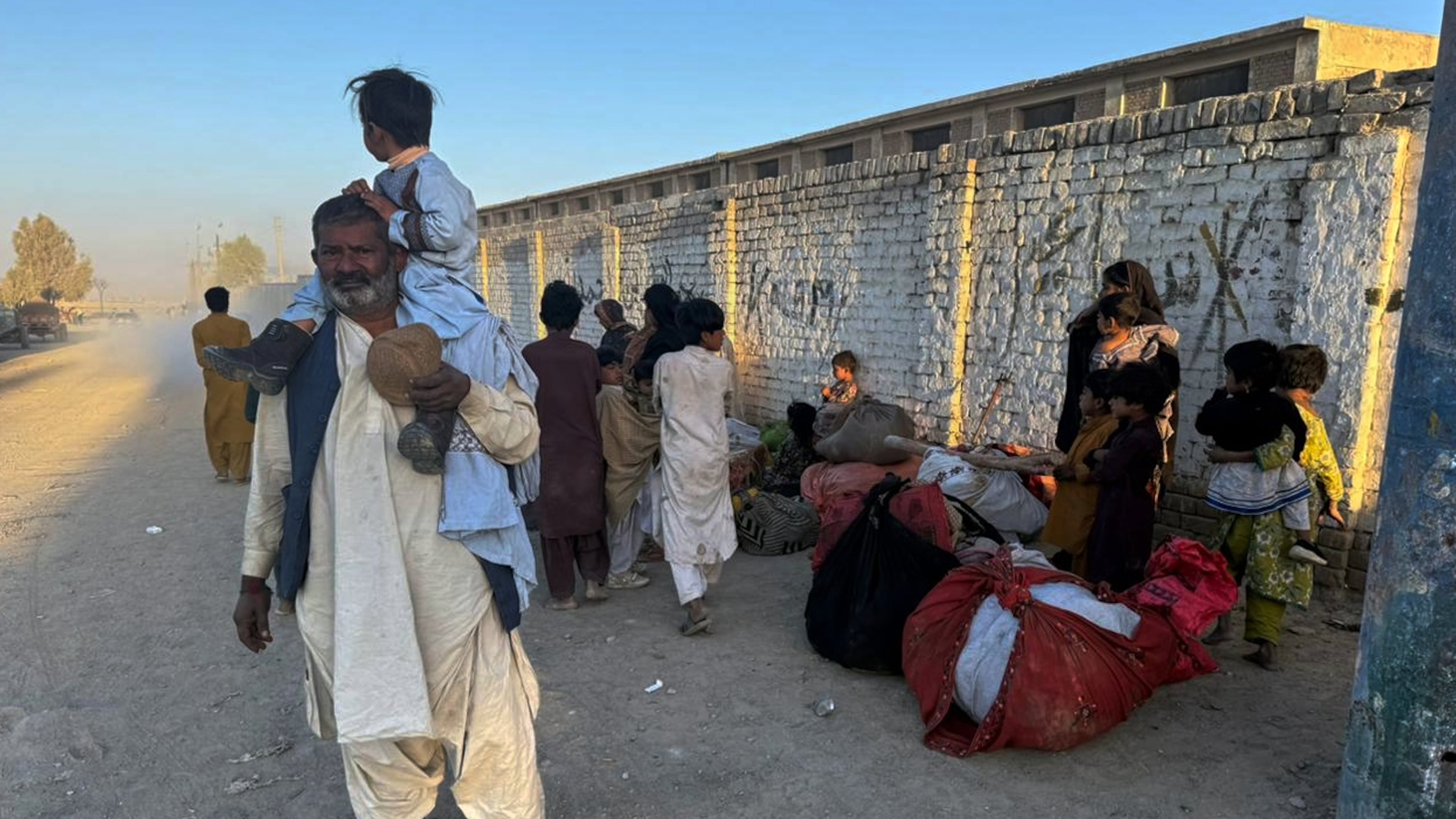 Local residents, who fled their homes following border clashes between Pakistan and Afghan forces, wait for transportation in Chaman, a town on the Pakistan side of the Afghanistan border, Wednesday, Oct. 15, 2025. (AP Photo/H. Achakzai)