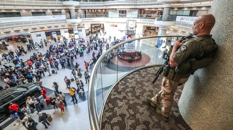 Atlanta police officer, J. Overbaugh overlooks lines of travelers in the atrium at Hartsfield-Jackson Atlanta International Airport early Monday morning, May 17, 2021.