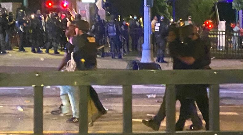 Two men are led away from a demonstration near Centennial Olympic Park that turned violent on Friday, May 29, 2020. Most of the demonstrators gathered for a non-violent protest of police misconduct. Some hurled objects at police and looted nearby buildings. ERIC STIRGUS/ESTIRGUS@AJC.COM AJC FILE PHOTO
