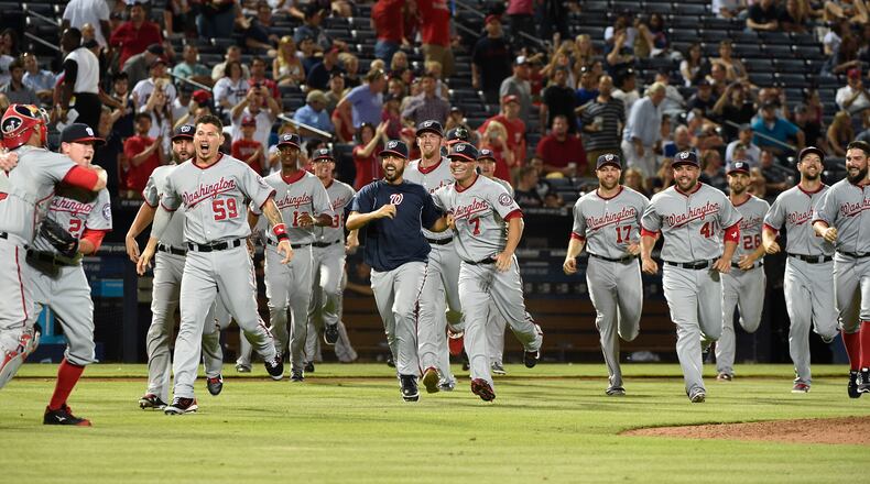 Washington Nationals teammates run out onto the field to congratulate pitcher Drew Storen (22) and catcher Wilson Ramos after clinching the NL East division against the Atlanta Braves in a baseball game Tuesday, Sept. 16, 2014, in Atlanta. Washington won 3-0. (AP Photo/David Tulis) Nationals became 11th team to celebrate something on Braves' field since 1992.