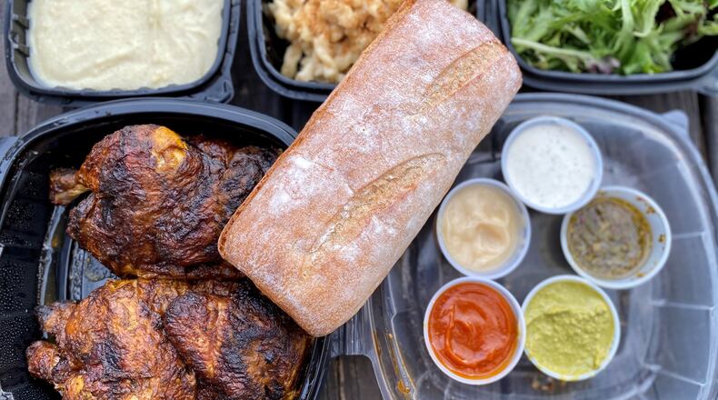 This takeout order from Fire Hen includes a whole chicken with French bread, dipping sauces, and sides (mashed potatoes, fondu mac and cheese and mixed green salad). Wendell Brock for The Atlanta Journal-Constitution