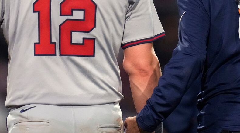 Atlanta Braves' Sean Murphy (12) has his right elbow examined by trainer George Poulis after getting hit by a pitch by Boston Red Sox's Chase Anderson during the ninth inning of a baseball game Tuesday, June 4, 2024, at Fenway Park in Boston. (AP Photo/Charles Krupa)