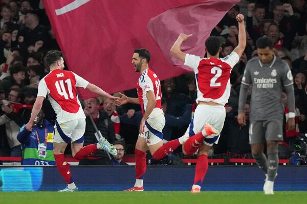 Arsenal's Mikel Merino, second left, celebrates with his teammate Declan Rice after scoring his side's third goal during the Champions League quarterfinal first leg soccer match between Arsenal and Real Madrid at the Emirates Stadium in London, Tuesday, April 8, 2025. (AP Photo/Frank Augstein)