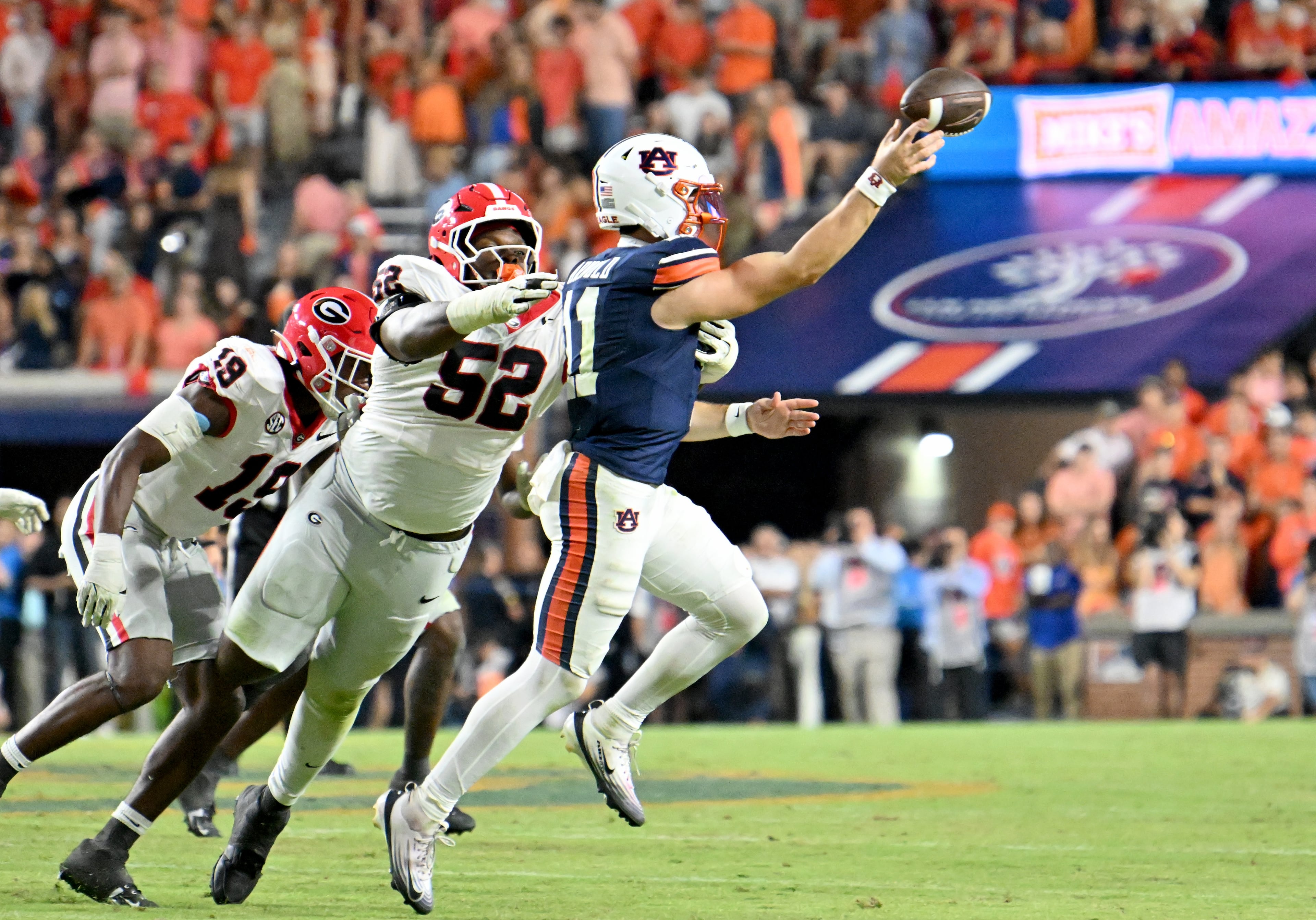 Auburn quarterback Jackson Arnold (11) gets off a pass under pressure from Georgia defensive lineman Christen Miller (52) during the second half in a NCAA college football game at Jordan-Hare Stadium, Saturday, October 11, 2025, in Auburn, Ala. Georgia won 20-10 overAuburn. (Hyosub Shin / AJC)