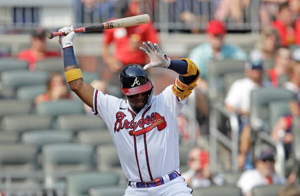 The Braves' Ronald Acuna raises his arms to avoid a pitch thrown by Miami Marlins pitcher Sandy Alcantara in the first inning of a baseball game Saturday, July 3, 2021, in Atlanta. (AP Photo/Ben Margot)