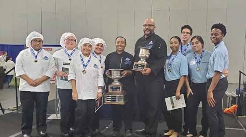 Meadowcreek High School Culinary and Management teams stand with Chef Tanisha Mott Tucker, center left, and Chef Jay Richardson, center right. COURTESY OF GWINNETT COUNTY PUBLIC SCHOOLS