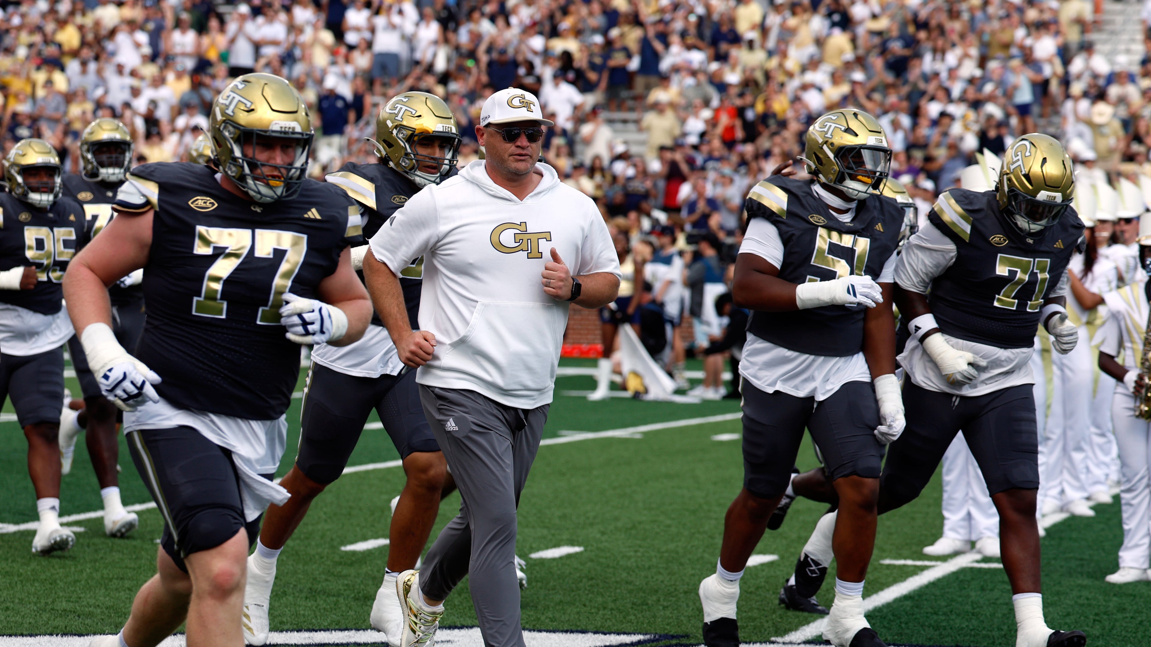 Georgia Tech coach Brent Key (center left) leads his team onto the field before the game against Temple on Saturday, Sept. 20, 2025, in Atlanta. key said of the 21-point win over the Owls: "Saturdays are to enjoy the win. Sundays are to be very transparent about ‘em and whether it’s a win, a loss, it doesn’t matter." (Butch Dill/AP)
