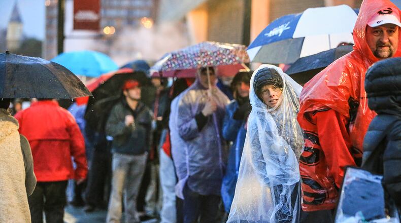 Caroline Wilbert pokes her head out from the crowd as they wait to get in the game in downtown Atlanta on Monday, January 8, 2018, at Atlanta’s Mercedes-Benz Stadium. (JOHN SPINK/JSPINK@AJC.COM)
