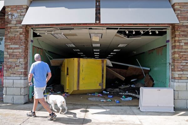 A floating garbage container crashed through the front of this business in the Eastgate Shopping Center after it was flooded during tropical storm Chantal, Monday, July 7, 2025, in Chapel Hill, N.C. (AP Photo/Chris Seward)