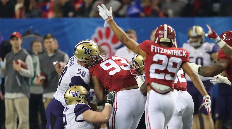 Alabama defender Jonathan Allen (left) recovers a Washington fumble during the first quarter in the Chick-fil-A Peach Bowl at the Georgia Dome on Saturday, Dec. 31, 2016, in Atlanta. Curtis Compton/ccompton@ajc.com