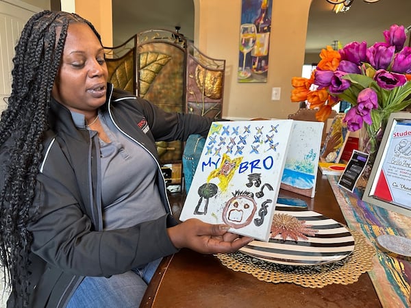 Lavonia McBride shows artwork produced by family and friends when they gathered Jan. 5 to commemorate what would have been the 20th birthday of her son Quafabian McBride. He was one of five men slain last year at Phillips State Prison, the most for any Georgia Department of Corrections facility. (Danny Robbins/For The Atlanta Journal-Constitution)