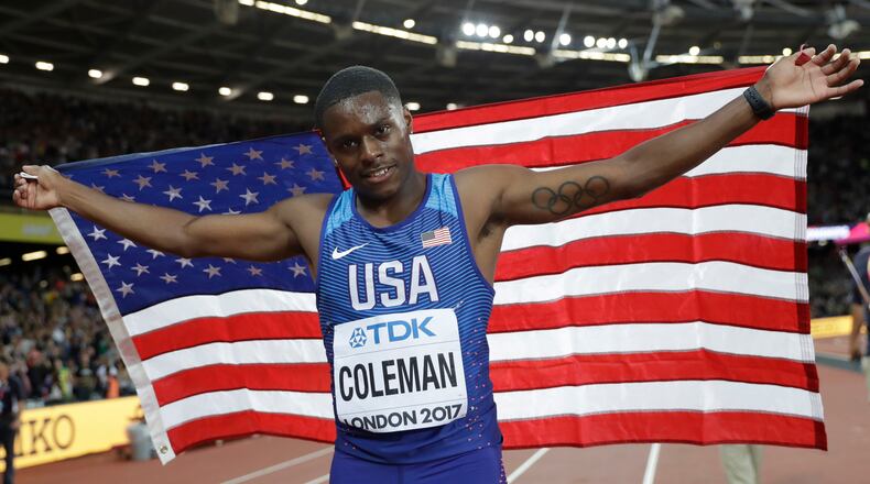United States' silver medal winner Christian Coleman, of Atlanta, poses with his national flag after the men's 100m final during the World Athletics Championships in London Saturday, Aug. 5, 2017.