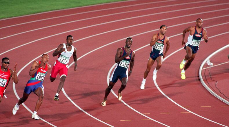 Michael Johnson (center) powers thru the final curve of the 200-meter event at the Olympic Stadium. (Cox Staff Photo/David Cruz)