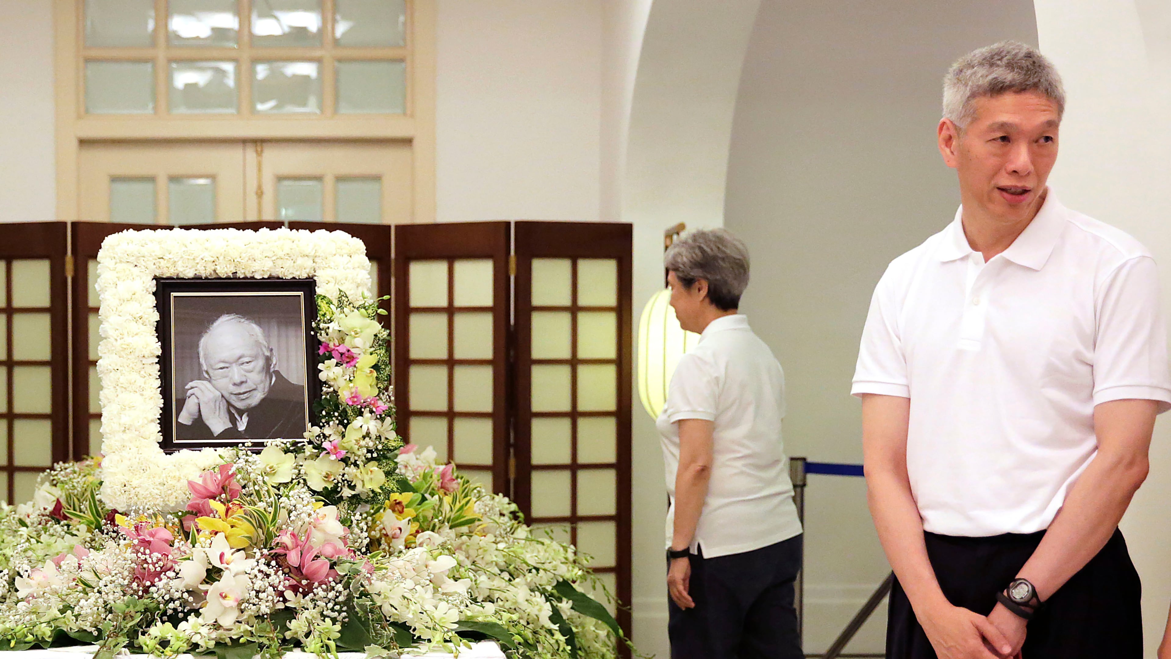 FILE - In this March 24, 2015, file photo, Prime Minister Lee Hsien Loong's brother, Lee Hsien Yang, right, receives friends and family members paying their respects to the late Lee Kuan Yew during a private family wake at the Istana or Presidential Palace in Singapore. (AP Photo/Wong Maye-E, File)
