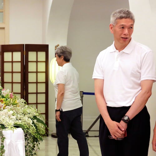 FILE - In this March 24, 2015, file photo, Prime Minister Lee Hsien Loong's brother, Lee Hsien Yang, right, receives friends and family members paying their respects to the late Lee Kuan Yew during a private family wake at the Istana or Presidential Palace in Singapore. (AP Photo/Wong Maye-E, File)