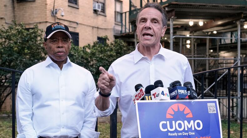 New York Mayor Eric Adams, left, and Democrat mayoral candidate Andrew Cuomo appear at a campaign event outside the George Washington Carver Houses, in New York, Thursday, Oct. 23, 2025. (AP Photo/Richard Drew)