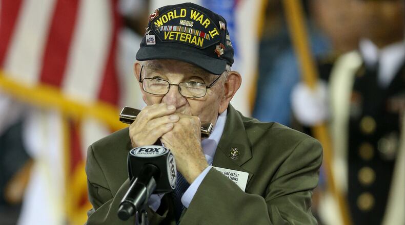 World War II veteran Peter Dupree plays the national anthem on his harmonica before the Pearl Harbor Invitational Dec. 7, 2016, in Pearl Harbor, Hawaii.