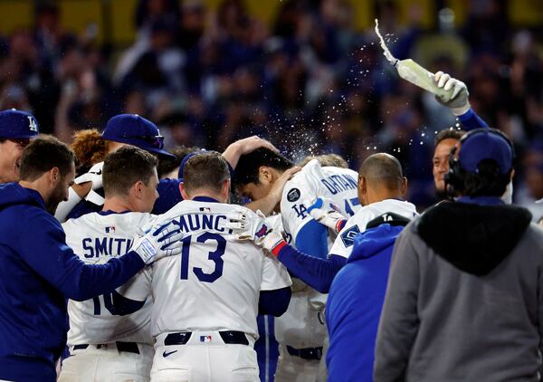Los Angeles Dodgers' Shohei Ohtani is congratulated after hitting a walk-off one-run home run against the Atlanta Braves during the ninth inning of a baseball game Wednesday, April 2, 2025, in Los Angeles. (AP Photo/Kevork Djansezian)