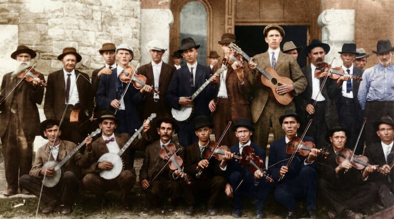 Known as “Seven-Foot Dilly,” the tall man in this colorized photo with the guitar was Atlanta fireman John Dilleshaw. Recordings of Dilleshaw will be accessible to the public on the Discography of American Historical Recordings through a partnership between Atlanta's Dust-to-Digital label and the University of California, Santa Barbara. (Courtesy of Dust-to-Digital)
