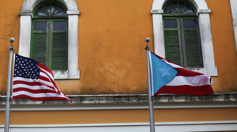 SAN JUAN, PUERTO RICO - JUNE 30: An American flag and Puerto Rican flag fly next to each other in Old San Juan a day after the Puerto Rican Governor Alejandro Garcia Padilla gave a televised speech regarding the governments $72 billion debt on June 30, 2015 in San Juan, Puerto Rico. The Governor said in his speech that the people will have to sacrifice and share in the responsibilities for pulling the island out of debt. (Photo by Joe Raedle/Getty Images)