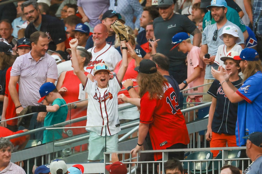 An Atlanta Braves fan catches a ball in the stands during the first inning of the MLB All-Star Game at Truist Park in Atlanta on Tuesday.
