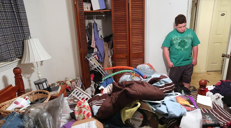 Connor Pierce, now 12, pauses after entering the room where he found his mother, Stephanie Futrell, dead from an overdose on heroin laced with fentanyl. The room has remained closed and undisturbed since she died on the day after Thanksgiving two years ago, her items still covering the room and the bed as they were on that tragic day. Curtis Compton /ccompton@ajc.com