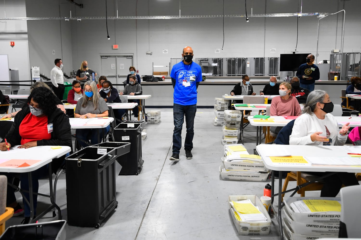 An observer from the Carter Center walks the area as votes for President are recounted at the Gwinnett County elections office on Friday, Nov.13, 2020 in Lawrenceville. (JOHN AMIS FOR THE ATLANTA JOURNAL-CONSTITUTION)