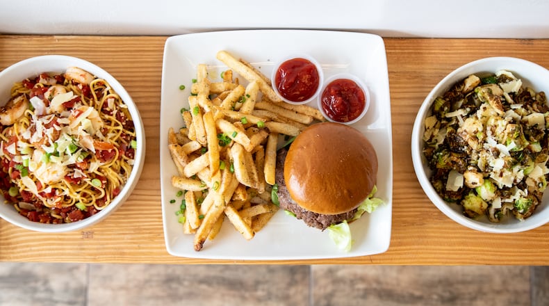 Che Butter Jonez's offerings include (from left) Who Let Mookie Make the Pasta, a popular lamb burger, and Flash Fried Brussels Sprouts. Mia Yakel for The AJC